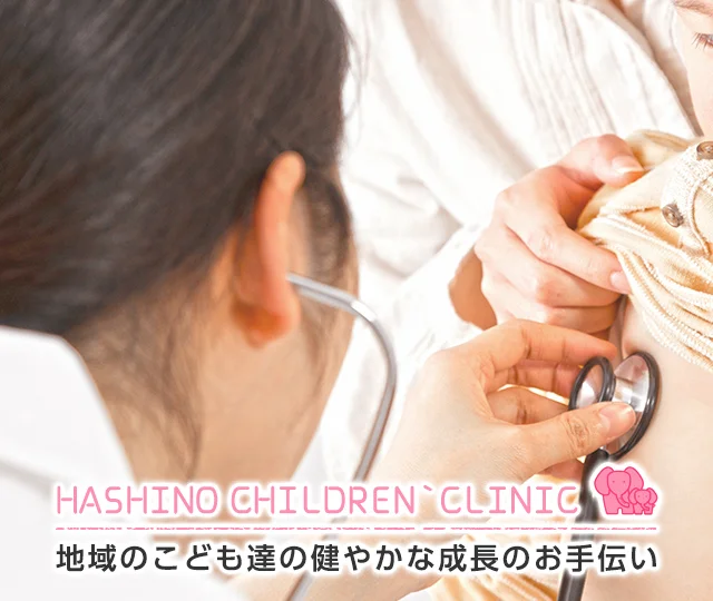 小児科医が保護者のそばで子どもの診察をしている様子