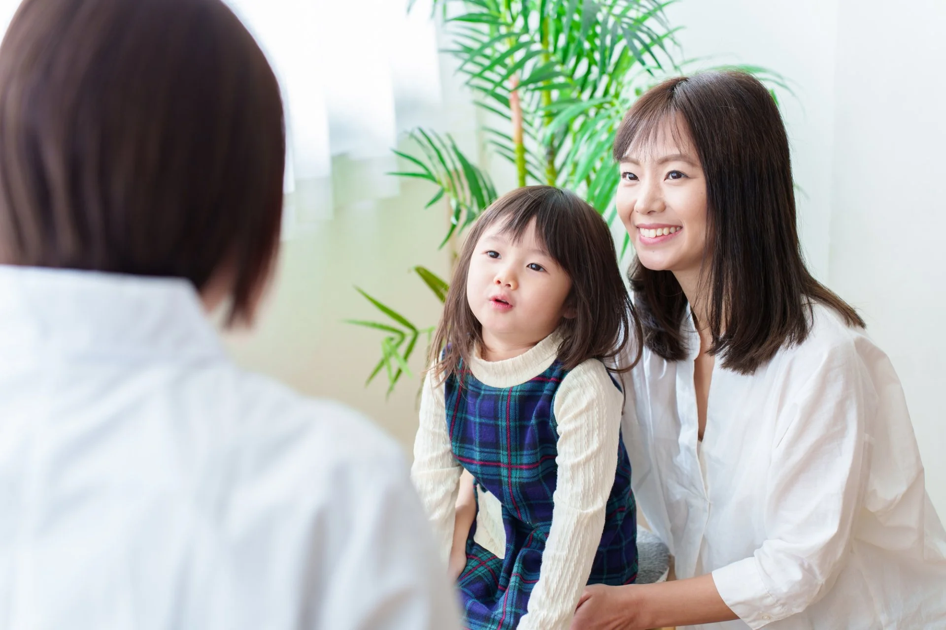 診察室で聴診器を使い子どもの体調を確認する小児科医